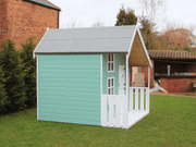 Children's playhouse painted in blue with white accents viewed from the left side. 