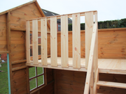 Internal bunk in children's playhouse with safety barrier and railing. 