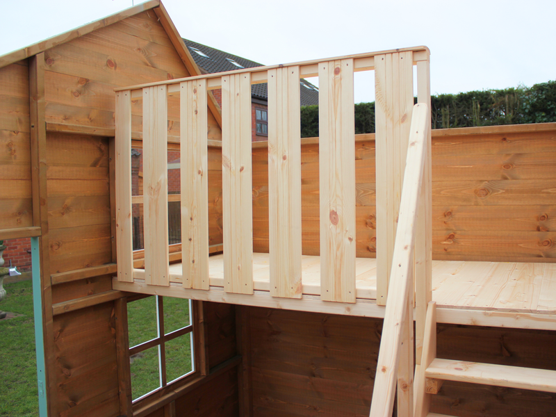 Internal bunk in children's playhouse with safety barrier and railing. 