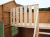 Internal bunk in children's playhouse with safety barrier and railing. 