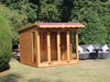 Wooden summerhouse with red roof tiles, large double doors, large front and side windows viewed from the left side. 