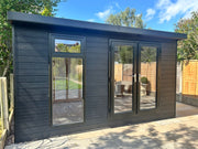 Dark grey, wooden garden building with double doors, tall front window. Viewed from the front. 