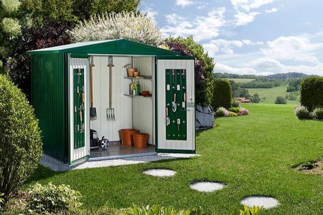 Europa steel shed in dark green, set in a stunning landscape, open to display various tools being stored inside 