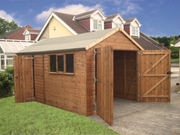 Large wooden garage with large opened double doors, single door on left side, side opening windows on left side, viewed from the left side. 