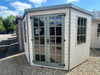 Georgian Corner Summerhouse with double doors and two side windows, painted white with green accents and viewed from the front