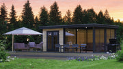 Large wooden summerhouse with double doors, large terrace area on right side. Viewed from the front/right side. 
