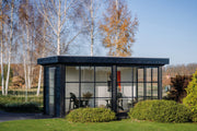 Wooden summerhouse with 2 glass walls, 1 side door. Viewed from the front/left side.