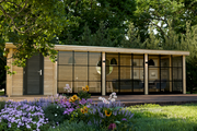 Large, wooden summerhouse with single door, large windows along the front. Viewed from the front. 