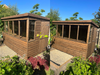 Two side-by-side images of the Lunar Potting Shed in a natural timber finish, both viewed from the left of the building