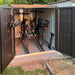 MiniGarage steel outdoor bike store in metallic dark grey finish in a happy customers garden