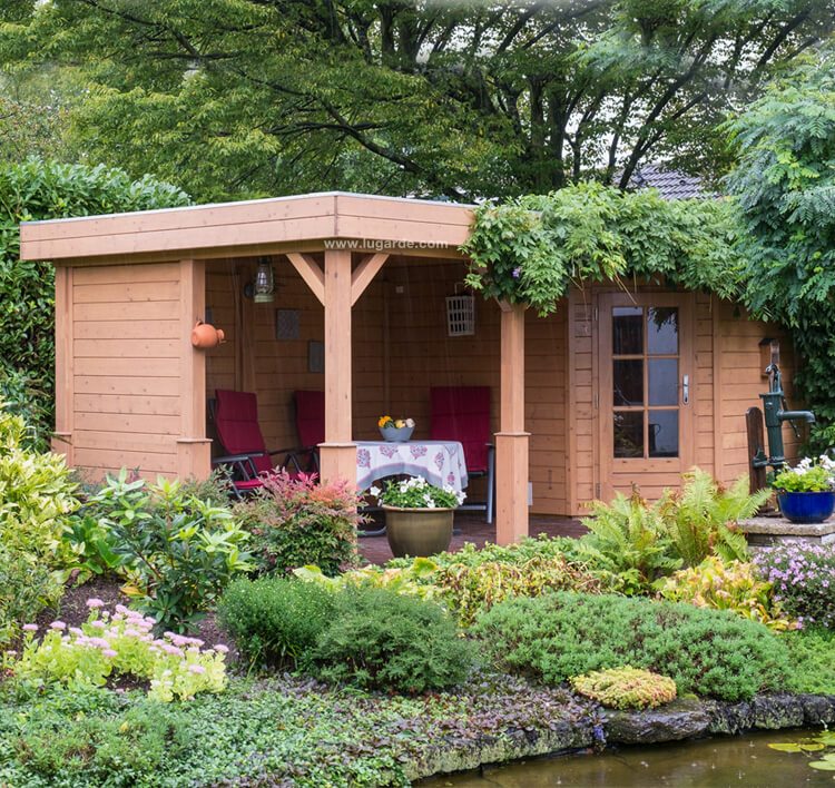 Large, wooden, pentagonal summerhouse with canopy on left side. Viewed from front/left side. 