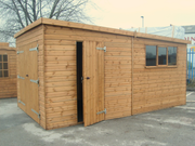 Pent style garage with large double doors, side door, three side windows, viewed from the right side. 