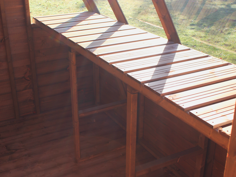 Interior of wooden potting shed, close up of slatted staging. 