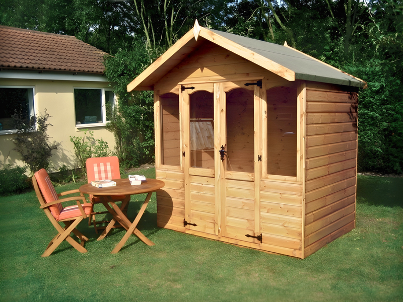 Wooden summerhouse with double doors and two windows on either side of door. Viewed from the front/right side. 