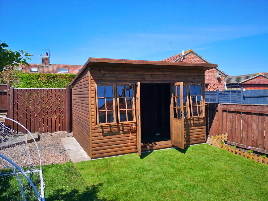 The Studio Summerhouse with open double doors and four opening side windows, viewed from the left