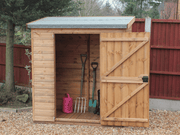 Small wooden tool shed, single door open showing interior, viewed from the front. 