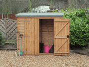 Small wooden tool shed with one door open, one shut, viewed from the front. 