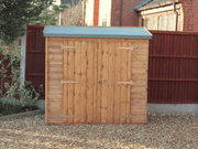 Small wooden tool shed with double doors viewed from the front. 