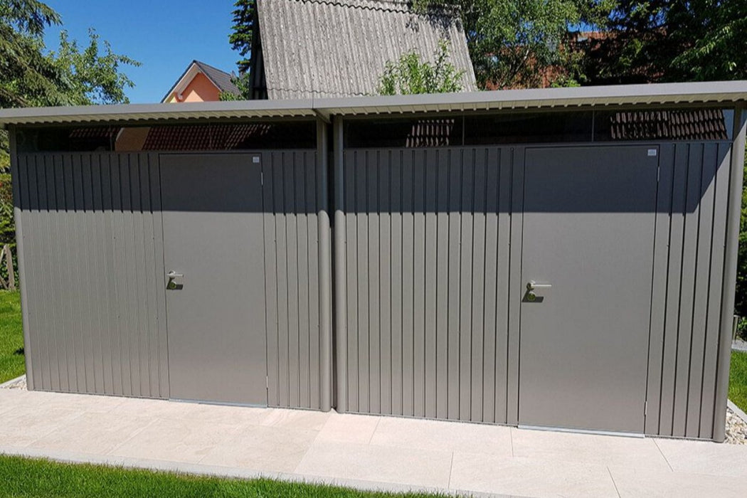 Two AvantGarde steel sheds side by side in a happy customer's garden, pictured in metallic quartz grey finish