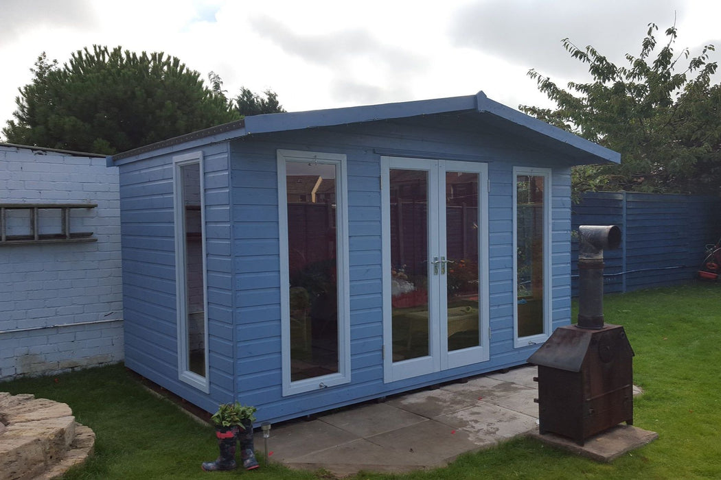 The Hampshire summerhouse in a garden painted in blue