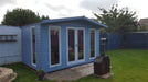 The Hampshire summerhouse in a garden painted in blue