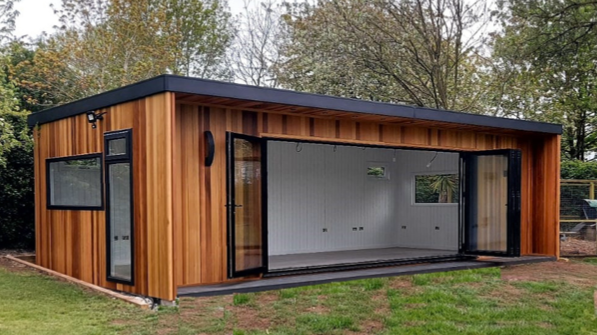 A contemporary style Dalbury garden room with full pane windows and doors, featuring a cedar clad exterior and a black rubber roof.