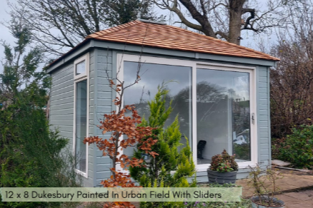 A traditional hip roof garden building with sliding doors, painted in urban field with a shingled roof.