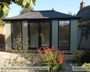 A green painted garden room called the Dukesbury with a traditional hip roof, featuring large windows and double doors.